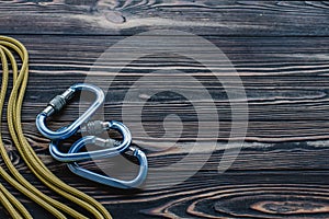 Time for some adventures. Isolated photo of climbing equipment. Part of carabiner lying on the wooden table