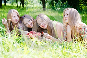 Time for strawberry: 4 young beautiful brunette & blond young women girl friends having fun harvested strawberries in summer