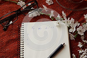 Time for tea, empty notebook, pen and cherry flowers on table