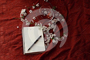 Time for tea, empty notebook, pen and cherry flowers on table