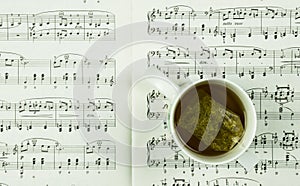 Time for tea and music concept with cup of tea and music notes.