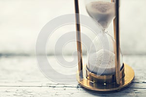 Time is ticking - hourglass on the table with copy space