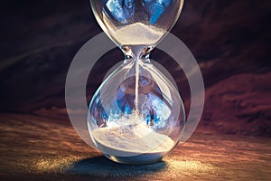 Time ticking Modern hourglass in running time on a wooden table