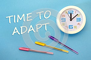 Time To Adapt - lettering on a blue background and clock