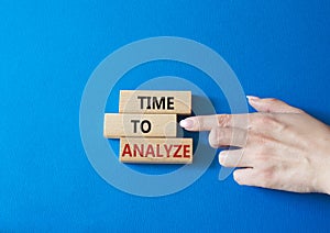 Time to Analyze symbol. Concept word Time to Analyze on wooden blocks. Businessman hand. Beautiful blue background. Business and