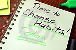 Time to change habits today written on a notepad. photo