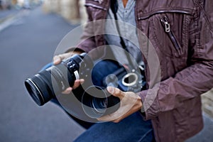 Time to clean this lens. A young man removing the lens from his camera.