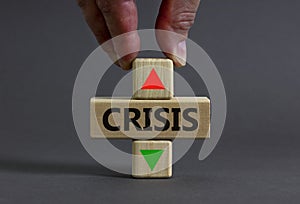 Time to crisis symbol. Businessman holds a wooden cubes with up icon. Wooden cubes with the concept word Crisis. Beautiful grey