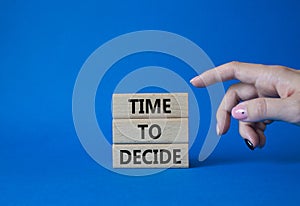 Time to decide symbol. Concept words Time to decide on wooden blocks. Beautiful blue background. Busimessman hand. Business and