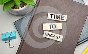 Time To Engage. Conceptual image. text on wood cubes. text in black letters on wood blocks