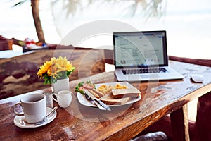 Time to enjoy breakfast and write your best blog yet. a laptop and freshly made breakfast on a table outside.