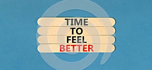 Time to feel better symbol. Concept words Time to feel better on wooden stick. Beautiful blue table blue background. Motivational