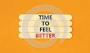 Time to feel better symbol. Concept words Time to feel better on wooden stick. Beautiful orange table orange background.