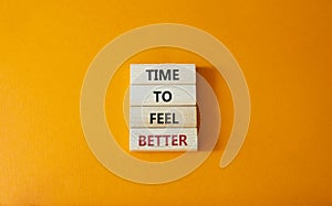 Time to feel better symbol. Wooden blocks with words Time to feel better. Beautiful orange background. Medicine and Time to feel