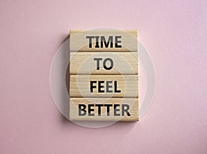 Time to feel better symbol. Wooden blocks with words Time to feel better. Beautiful pink background. Medicine and Time to feel