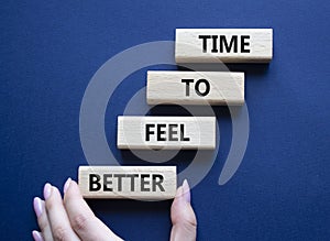 Time to feel better symbol. Wooden blocks with words Time to feel better. Businessman hand. Beautiful deep blue background.