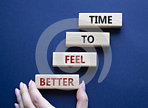 Time to feel better symbol. Wooden blocks with words Time to feel better. Businessman hand. Beautiful deep blue background.