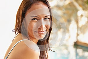 Time to get my summer on. Portrait of an attractive young woman sitting by the edge of the pool.