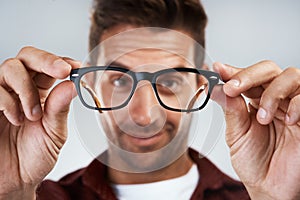 Time to get my vision back. Portrait of a cheerful young man wearing glasses and smiling brightly while standing against