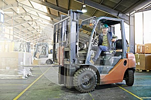 Time to get things moving around here. Portrait of driver in a forklift on the factory floor.