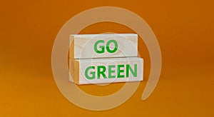 Time to go green ecology symbol. Concept words Go green on wooden blocks on a beautiful orange background. Business, ecology and