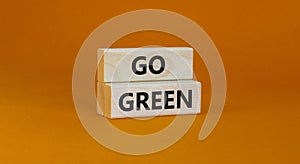 Time to go green ecology symbol. Concept words Go green on wooden blocks on a beautiful orange background. Business, ecology and