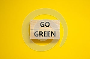 Time to go green ecology symbol. Concept words Go green on wooden blocks on a beautiful yellow background. Business, ecology and