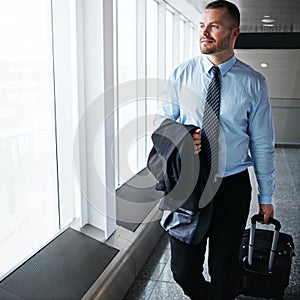 Time to head back to the office. an executive businessman walking through an airport during a business trip.