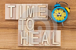 Time to heal- text in vintage letters on wooden blocks with ala