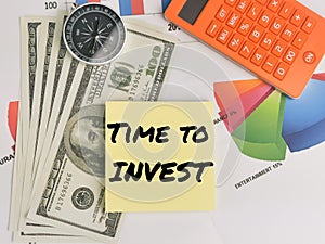 Time to invest written on yellow paper note with calculator,compass,money and chart.