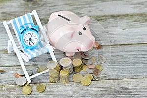 Time to invest your savings concept with pile of money , alarm clock and piggy bank