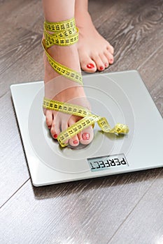 Time to lose kilograms with woman feet stepping on a weight scale