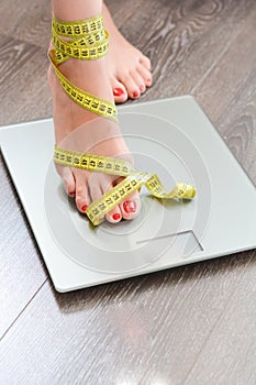 Time to lose kilograms with woman feet stepping on a weight scale photo