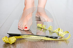 Time to lose kilograms with woman feet stepping on a weight scale