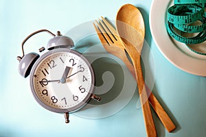 Time to lose weight , eating control or time to diet concept ,a alarm clock with healthy tool concept decoration on blue