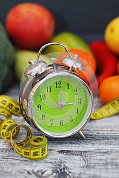 Time to lose Weight. Fruit, Vegetable and Alarm Clock on the table, Diet and Fitness concept.