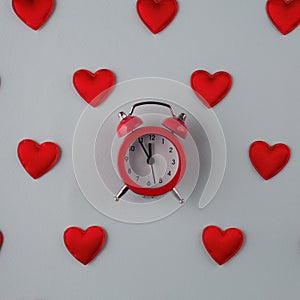 time to love concept from small red hearts with clock on blue background