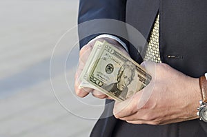 Time to make money. businessman in a suit with a wad of cash. businessman recounts profits.