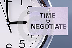 The hand of the clock points to list with text Time to negotiate photo