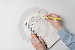 Time to Notice in notepad on white background. Words handwritten. Women`s hands and Notebook on white background