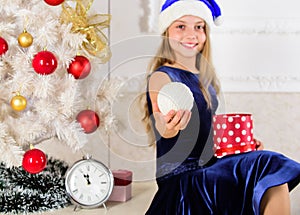 Time to open christmas gifts. Happy new year concept. Kid girl sit near christmas tree hold gift box. Little girl santa
