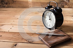 Time to payment concept. retro bell clock timed at 11 o`clock on wood background