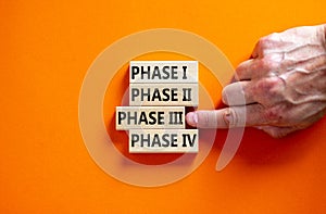 Time to phase 3. Wooden blocks form the words `phase, 1, 2, 3, 4` on orange background. Male hand. Beautiful background. Busines