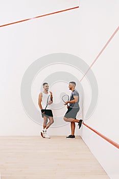 A time to play and a time to socialise. two young men chatting after playing a game of squash.