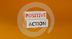 Time to positive action symbol. Wooden blocks with concept words `Positive action`. Beautiful orange background. Business and