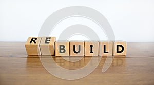 Time to rebuild symbol. Turned wooden cubes and changed the word `build` to `rebuild`. Beautiful wooden table, white backgroun