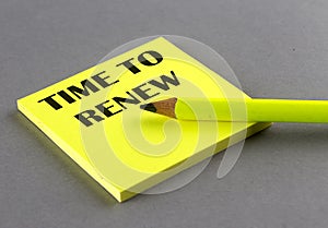 TIME TO RENEW text written on a sticky on grey background