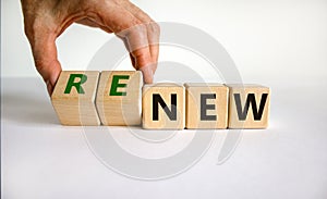 Time to renew. The words `new` and `renew` on wooden cubes. Male hand.  Beautiful white background, copy space