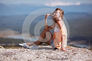 Time to rest. Relaxing moment. Contemplation and dreaming. Smiling woman sitting on rock and looking away thoughtfully