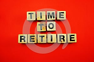 Time to retire word created with cubes alphabet letters on blue background